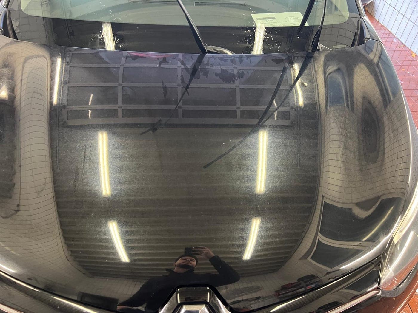 Schwarze Motorhaube vor der Politur: matt mit Kratzern und Hologrammen